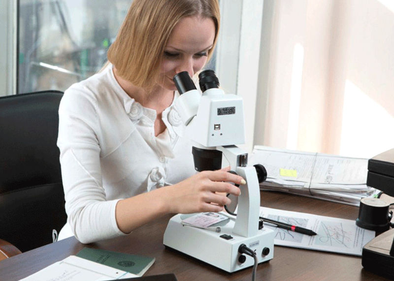 Девушка смотрит в микроскоп